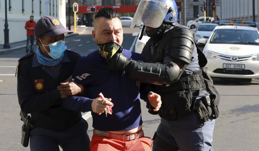 A demonstrator working in the hospitality industry is arrested by police during a protest against lockdown regulations in the streets close to Parliament in Cape Town, South Africa, Friday July 24, 2020. People from various hospitality or restaurant establishments marched on parliament to raise awareness about the industry's declining revenues amid the Covid-19 lockdown. (AP Photo/Nardus Engelbrecht)