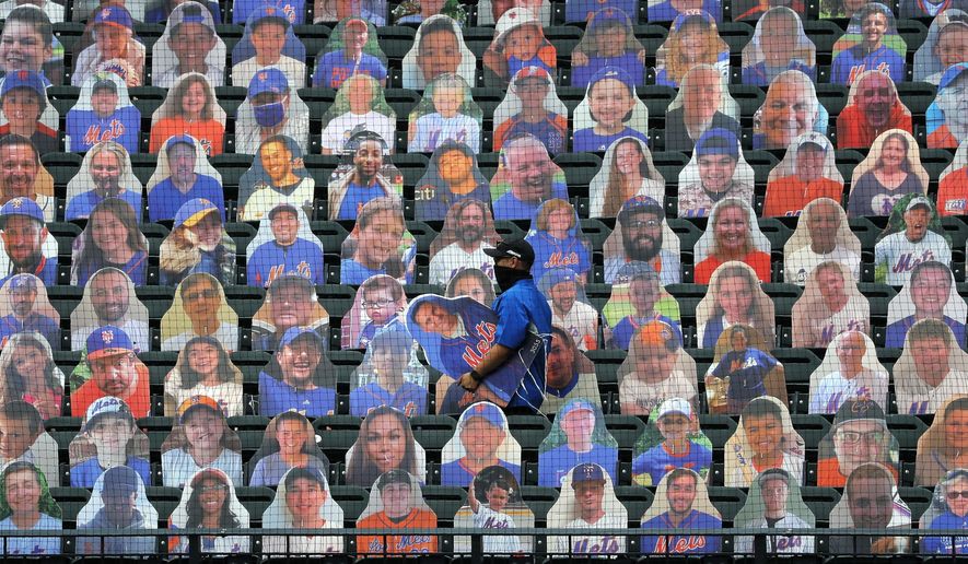 New York Mets employees place cutouts of fans in the seats before the opening day baseball game between the Mets and the Atlanta Braves at Citi Field, Friday, July 24, 2020, in New York. (AP Photo/Seth Wenig)
