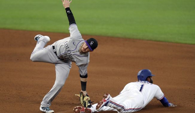 Colorado Rockies shortstop Trevor Story (27) makes the tag on Texas Rangers&#x27; Elvis Andrus (1) who was attempting to steal in the fourth inning of a baseball game Saturday, July 25, 2020, in Arlington, Texas. (AP Photo/Richard W. Rodriguez)