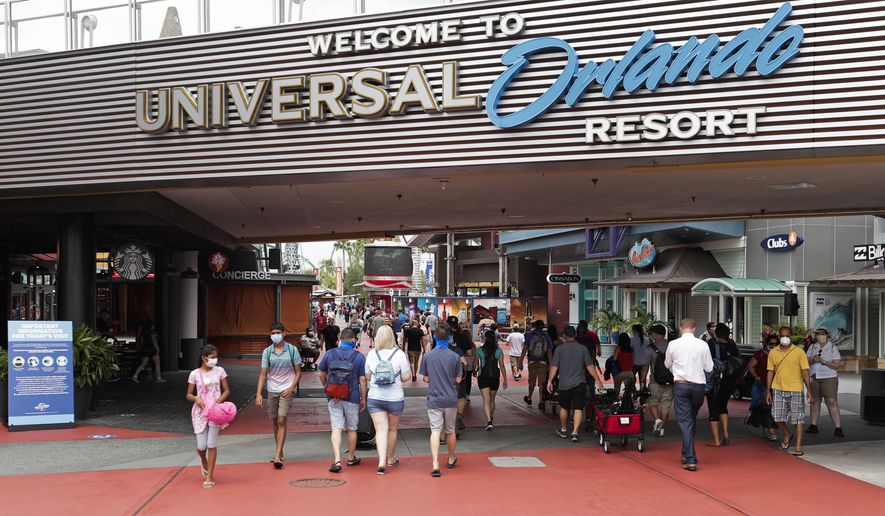 FILE—In this June 3, 2020 file photo, visitors arrive at Universal Studios, in Orlando, Fla. Amusement parks of all sizes are adjusting everything from selling tickets to serving meals while trying to reassure the public and government leaders that they&#x27;re safe to visit amid the coronavirus crisis and warnings against large gatherings. (AP Photo/John Raoux, File)