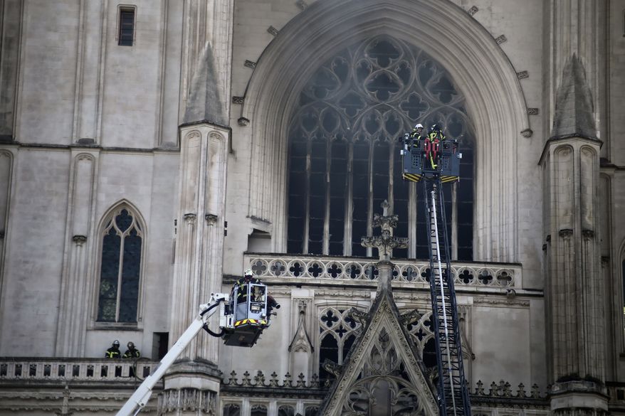 Fire fighters brigade work to extinguish the blaze at the Gothic St. Peter and St. Paul Cathedral, in Nantes, western France, July 18, 2020. French authorities detained and charged a repentant church volunteer Sunday, July 26, 2020 after he told investigators that he was responsible for an arson attack that badly damaged a 15th-century Gothic cathedral. (AP Photo/Romain Boulanger) ** FILE **