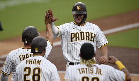 San Diego Padres designated hitter Wil Myers, top right, celebrates with Ty France after hitting a three-run home run during the fourth inning of a baseball game against the Arizona Diamondbacks in San Diego, Saturday, July 25, 2020. (AP Photo/Kelvin Kuo)