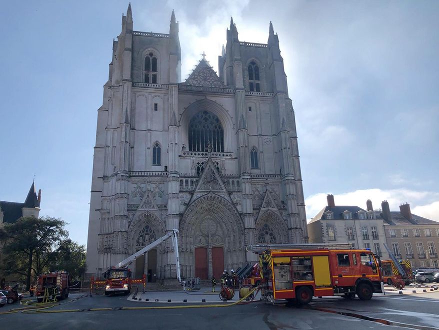 FILE - In this July 18, 2020, file photo, fire fighters brigade work to extinguish the blaze at the Gothic St. Peter and St. Paul Cathedral, in Nantes, western France. French authorities detained and charged a repentant church volunteer Sunday, July 26, 2020 after he told investigators that he was responsible for an arson attack that badly damaged a 15th-century Gothic cathedral. (AP Photo/Laetitia Notarianni, File)