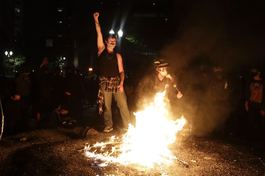 Demonstrators rally around a fire during a Black Lives Matter protest at the Mark O. Hatfield United States Courthouse Saturday, July 25, 2020, in Portland, Ore. (AP Photo/Marcio Jose Sanchez) **FILE**