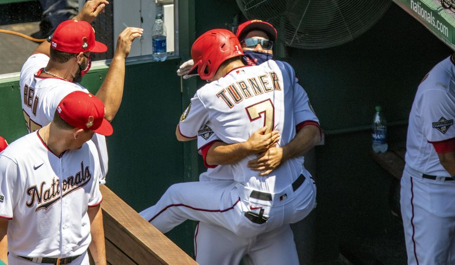 Washington Nationals' Trea Turner jumps into the arms of a teammate after his solo home run during the third inning of a baseball game against the New York Yankees at Nationals Park, Sunday, July 26, 2020, in Washington. (AP Photo/Alex Brandon)