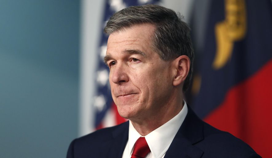 FILE - Gov. Roy Cooper listens to a question during a briefing at the Emergency Operations Center in Raleigh, N.C., Tuesday, July 14, 2020, amid the coronavirus pandemic. As many as 1 million families in North Carolina have fallen behind on their electric, water and sewage bills, threatening residents and their cities with severe financial hardship unless federal lawmakers act to approve more emergency aid. Last week Cooper urged Congress to act swiftly and adopt a wide array of new federal spending, stressing in a letter that the “actions you take in the next few weeks are vital to our ability to emerge from this crisis.” (Ethan Hyman/The News &amp;amp; Observer via AP, file)