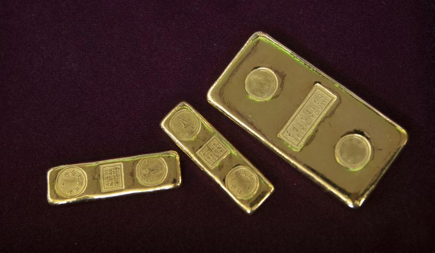 FILE - In this April 16, 2020, file photo, a customer puts gold bars on basket for sell to a gold shop in Bangkok, Thailand. The price of gold surged more than $30 on Monday, July 27, 2020 to over $1,926 per ounce as investors step up buying of the precious metal often sought in times of uncertainty. Gold was trading at $1,926.20 by early afternoon in Asia, up 1.5%, after surging over the weekend. (AP Photo/Sakchai Lalit, File)