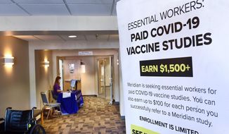 In this file photo, a poster is displayed in the entrance way looking for volunteers as the world&#39;s biggest study of a possible COVID-19 vaccine, developed by the National Institutes of Health and Moderna Inc.,  gets underway Monday, July 27, 2020, in Binghamton, N.Y. In a separate front on the coronavirus pandemic, NIH will run a clinical test of manufactured antibodies, both on hospitalized and non-hospitalized COVID patients. (AP Photo/Hans Pennink)