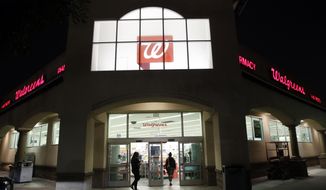 FILE - In this June 24, 2019 file photo, shoppers enter a Walgreens store in Los Angeles. Walgreens leader Stefano Pessina will step down as CEO and become executive chairman of the drugstore chain’s board once they pick a new leader. The company also said Monday, July 27, 2020, that its current executive chairman, former McDonald’s CEO Jim Skinner, will leave that role but remain on the board.   (AP Photo/Marcio Jose Sanchez, File)