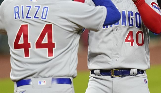 Chicago Cubs&#x27; Anthony Rizzo (44) and Willson Contreras (40) celebrate after they each scored a run in the first inning of a baseball game against the Cincinnati Reds at Great American Ballpark in Cincinnati, Monday, July 27, 2020. (AP Photo/Bryan Woolston)