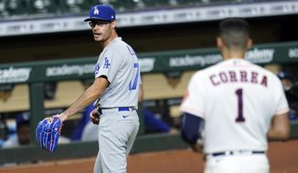 Los Angeles Dodgers relief pitcher Joe Kelly (17) looks back at Houston Astros&#39; Carlos Correa (1) after the sixth inning of a baseball game Tuesday, July 28, 2020, in Houston. Both benches emptied during the exchange. (AP Photo/David J. Phillip) ** FILE **