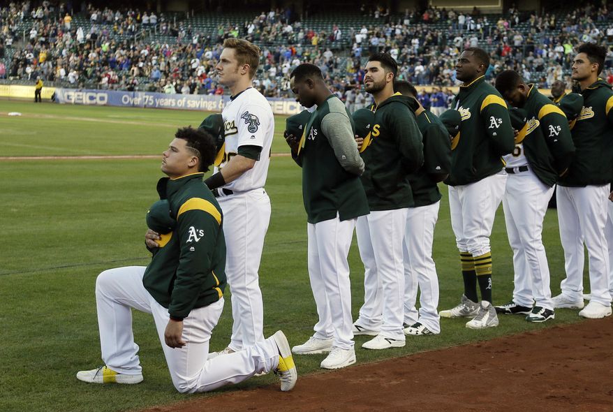 FILE - In this Sept. 23, 2017, file photo, Oakland Athletics catcher Bruce Maxwell kneels during the national anthem before the start of a baseball game against the Texas Rangers in Oakland, Calif. The New York Mets have agreed to a minor league contract with Maxwell, the first major league player to kneel during the national anthem to protest racial injustice in 2017, according to a person familiar with the deal.  (AP Photo/Eric Risberg, File)