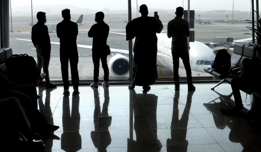 Passengers wear face masks to help curb the spread of the coronavirus as they watch aircraft on the tarmac as they wait for their flight at the King Abdulaziz International Airport in Jiddah, Saudi Arabia, Tuesday, July 28, 2020. Few flights are scheduled for international departures only but the authorities have eased domestic travel restrictions since June. (AP Photo)