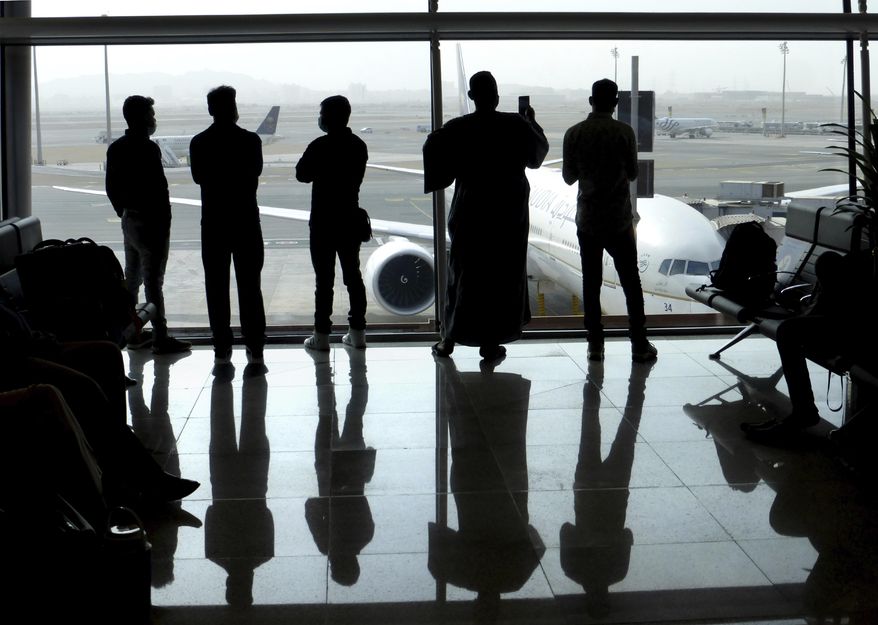Passengers wear face masks to help curb the spread of the coronavirus as they watch aircraft on the tarmac as they wait for their flight at the King Abdulaziz International Airport in Jiddah, Saudi Arabia, Tuesday, July 28, 2020. Few flights are scheduled for international departures only but the authorities have eased domestic travel restrictions since June. (AP Photo)