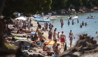 Sunbathers enjoy the beach in Pollença, in the Balearic Island of Mallorca, Spain, Tuesday, July 28, 2020. The U.K. government&#39;s recommendation against all but essential travel to the whole of Spain means that all travelers arriving in Britain from that country will have to undergo a 14-day quarantine. (AP Photo/Joan Mateu)