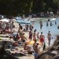 Sunbathers enjoy the beach in Pollença, in the Balearic Island of Mallorca, Spain, Tuesday, July 28, 2020. The U.K. government&#39;s recommendation against all but essential travel to the whole of Spain means that all travelers arriving in Britain from that country will have to undergo a 14-day quarantine. (AP Photo/Joan Mateu)