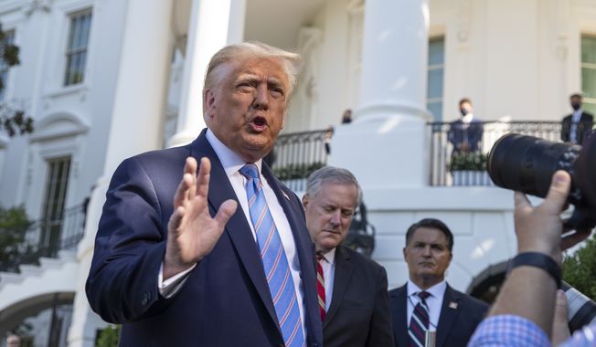 Then-President Donald Trump, accompanied by White House Chief of Staff Mark Meadows, second from left, speaks with reporters as he walks to Marine One on the South Lawn of the White House, Wednesday, July 29, 2020, in Washington. (AP Photo/Alex Brandon) **FILE**