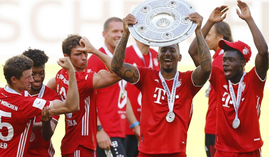 FILE - In this June 27, 2020, file photo, Munich&#x27;s Jerome Boateng lifts the trophy after the German Bundesliga soccer match between VfL Wolfsburg and FC Bayern Munich in Wolfsburg, Germany. Boateng has talked to teammates about the pain of facing racist abuse. (Kai Pfaffenbach/Pool Photo via AP, File)
