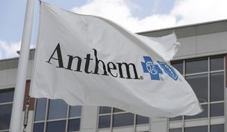 FILE - In this May 14, 2019, file photo a flag flies the outside of the corporate headquarters building of health insurance company Anthem is shown in Indianapolis. Anthem’s second-quarter profit doubled to nearly $2.3 billion, as a pandemic-induced drop in claims and a new business pushed the Blue Cross-Blue Shield insurer’s earnings past expectations.  But the nation’s second-largest insurer left its 2020 earnings forecast unchanged, following a pattern established by its competitors. (AP Photo/Michael Conroy, File)