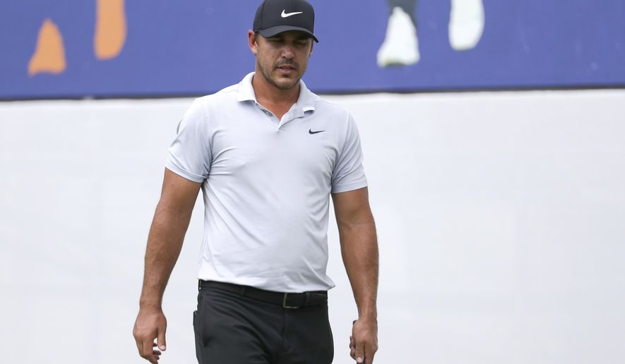 Brooks Koepka walks across the practice green at the World Golf Championships-FedEx St. Jude Invitational Wednesday, July 29, 2020, in Memphis, Tenn. Koepka, who won three times last year is trying to defend his FedEx St. Jude Invitational title with an injured left knee that has had him putting more weight on his right leg and affecting his game. (AP Photo/Mark Humphrey)
