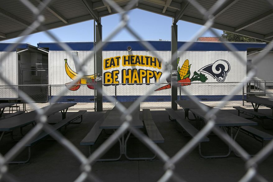 FILE - In this July 17, 2020, file photo, the cafeteria area of an elementary school is seen through a fence in Los Angeles. Earlier this month, Gov. Gavin Newsom said public and private K-12 schools would remain shuttered so long as the counties where they are located remain on a state monitoring list for the coronavirus. But he also said superintendents could submit waiver requests for elementary schools to reopen sooner. (AP Photo/Jae C. Hong, File)
