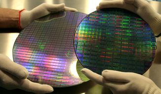 The dummies of a 200mm wafer, right, and a 300mm wafer, left, are seen at Advanced Micro Devices Inc. , in Dresden, Germany, Thursday, March 8, 2007.  AMD snared a huge slice of the microprocessor market from archrival Intel Corp., only to find that it might have paid too high a price for its victories. (AP Photo/Matthias Rietschel)