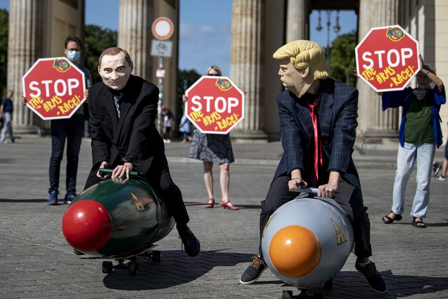 Two activists dressed up as U.S. President Trump and Russian President Putin ride two atomic bomb models during a protest for a world without nuclear weapons in front of the Brandenburg Gate in Berlin, Germany, July 30, 2020. Several peace and disarmament organizations as well as environmental protection groups demonstrated on the Pariser Platz for a nuclear weapons-free world before the start of negotiations between the USA and Russia on further action in nuclear arms control. (Fabian Sommer/dpa via AP)
