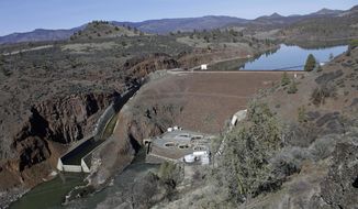 FILE - This March 3, 2020, file photo shows the Iron Gate Dam, powerhouse and spillway are on the lower Klamath River near Hornbrook, Calif. California Gov. Gavin Newsom has appealed directly to investor Warren Buffet to support demolishing four hydroelectric dams on a river along the Oregon-California border to save salmon populations that have dwindled to almost nothing. Newsom on Wednesday, July 28, 2020, wrote Buffet, urging him to back the Klamath River project, which would be the largest dam removal in U.S. history. (AP Photo/Gillian Flaccus, File)