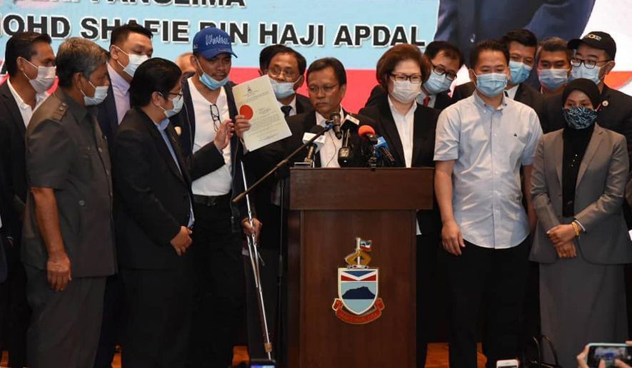 Sabah Chief Minister Shafie Apdal, centre, in Kota Kinabalu, Sabah, Malaysia Thursday, July 30, 2020. Shafie dissolved the state parliament to pave the way for polls after a ruling party politician claimed he had majority support of lawmakers to form a new government. (AP Photo)
