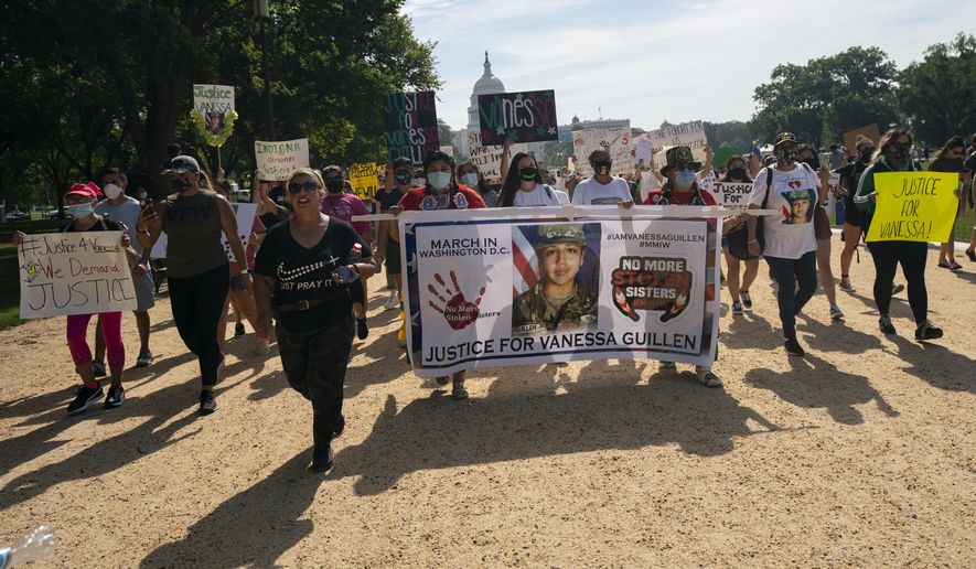 Supporters of the family of slain Army Spc. Vanessa Guillen march to the White House along the National Mall as Capitol Hill is seen in the distance after a news conference, Thursday, July 30, 2020, in Washington. (AP Photo/Carolyn Kaster)