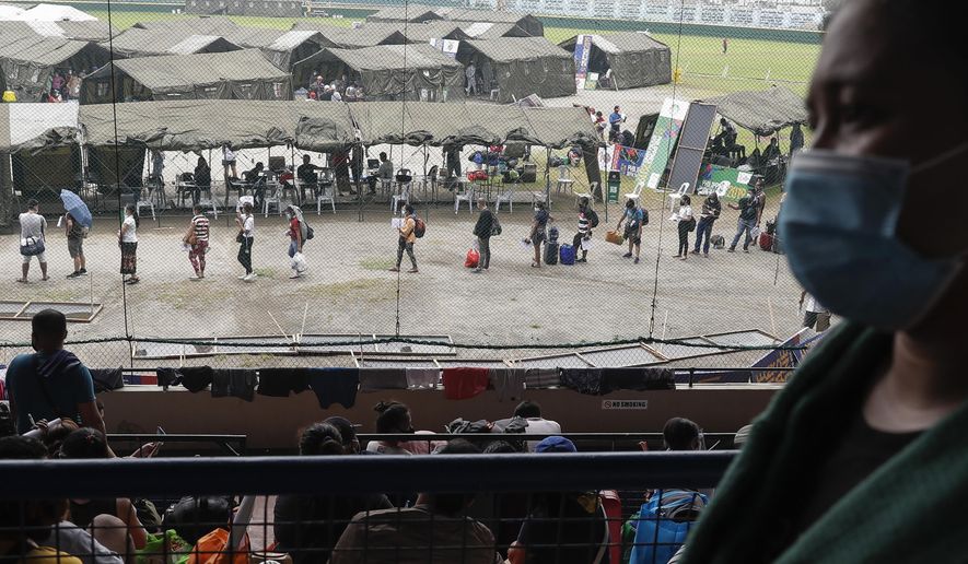 FILE - In this July 28, 2020, file photo, people wearing face masks line up to have their coronavirus rapid tests as they hope to use the government's transportation assistance program to return to their outlying provinces at a stadium in Manila, Philippines. The United Nations advised Southeast Asian nations to tackle inequality and green their economies to build a more resilient and inclusive future as they strive to recover from the COVID-19 pandemic, according to the policy report released Thursday, July 30, 2020. (AP Photo/Aaron Favila, File)