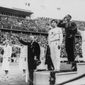 FILE - In this Aug. 11, 1936, file photo, America&#39;s Jesse Owens, second from right, salutes during the presentation of his gold medal for the long jump, after defeating Nazi Germany&#39;s Lutz Long, right, during the 1936 Summer Olympics in Berlin. Naoto Tajima of Japan, center, placed third. The performance of Jesse Owens will be honored in the stadium where he won four gold medals at the 1936 Olympic Games when the world championships are held in Berlin this month. (AP Photo/File)