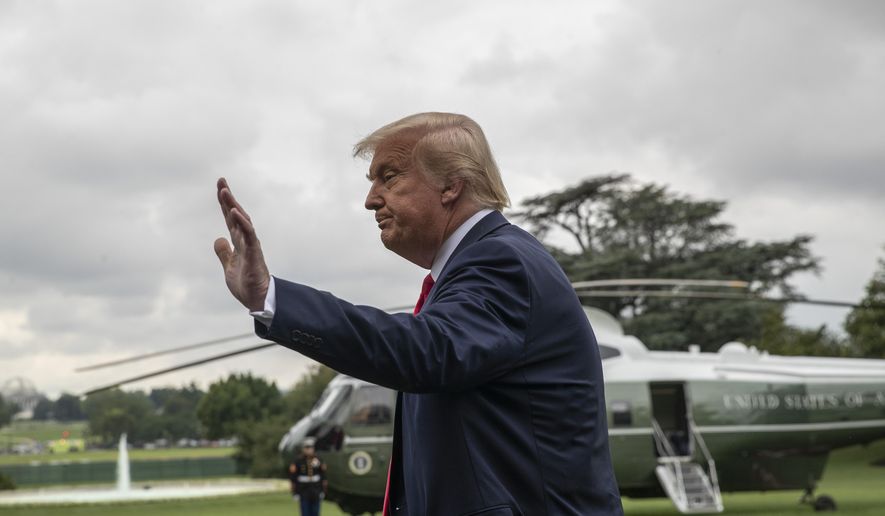 President Donald Trump waves to reporters as he walks to Marine One on the South Lawn of the White House, Friday, July 31, 2020, in Washington. Trump is en route to Florida. (AP Photo/Alex Brandon)