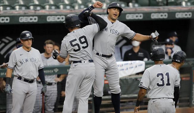 New York Yankees&#x27; Luke Voit (59) celebrates with Giancarlo Stanton, center right, after hitting a grand slam off Baltimore Orioles starting pitcher John Means during the first inning of a baseball game, Thursday, July 30, 2020, in Baltimore. Yankees&#x27; Gleyber Torres, Aaron Hicks (31) and Stanton scored on the grand slam. (AP Photo/Julio Cortez)