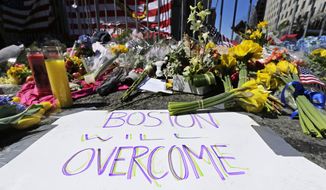 FILE - In this April 17, 2013 photograph, flowers and signs adorn a barrier, two days after two explosions killed three and injured hundreds, at Boylston Street near the of finish line of the Boston Marathon at a makeshift memorial for victims and survivors of the bombing.  A federal appeals court has overturned the death sentence of Dzhokhar Tsarnaev in the 2013 Boston Marathon bombing, Friday, July 31, 2020, saying the judge who oversaw the case didn&#39;t adequately screen jurors for potential biases.    (AP Photo/Charles Krupa, File)