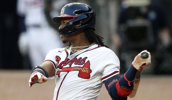 Atlanta Braves&#x27; Ronald Acuña Jr. follows through on an RBI double during the second inning of the team&#x27;s baseball game against the New York Mets on Saturday, Aug. 1, 2020, in Atlanta. (AP Photo/John Bazemore)