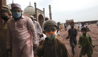 An Indian Muslim boy wears a protective mask in the colors of the Indian national flag, leaves  after offering Eid al-Adha prayer at the Jama Masjid in New Delhi, India, Saturday, Aug.1, 2020. Eid al-Adha, or the Feast of the Sacrifice, by sacrificing animals to commemorate the prophet Ibrahim&#x27;s faith in being willing to sacrifice his son. (AP Photo/Manish Swarup)