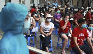 People wait in line for COVID-19 test in Hanoi, Vietnam, Friday, July 31, 2020. Vietnam reported on Friday the country&#39;s first ever death of a person with the coronavirus as it struggles with a renewed outbreak after 99 days without any cases. (AP Photo/Hau Dinh)