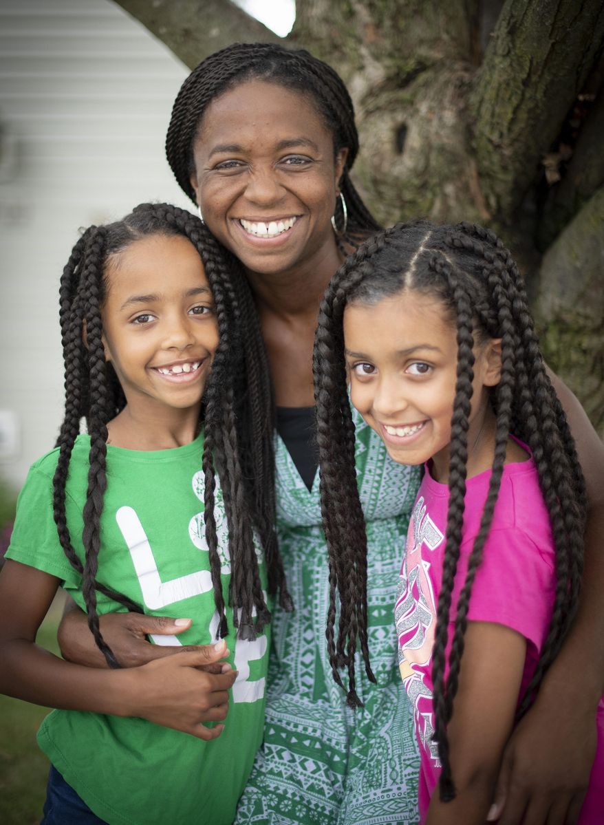 Leslie Granofsky sits with her daughters Chloe, 8 and Skyler, 9, at their Frederick, Md., home on July 24, 2020. Granofsky and other homeschooling mothers of Frederick are hosting a virtual panel to talk about homeschooling and how parents can get started. They realize that many families may choose homeschooling this year because of COVID-19 concerns. (Bill Green/The Frederick News-Post via AP)