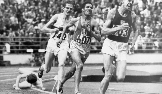 FILE - In this July 24, 1952, file photo, British athlete Christopher &amp;quot;Chris&amp;quot; Chataway falls as Emil Zatopek of Czechoslovakia, followed by Alain Mimoun of France and German bronze medal winner Herbert Schade, leads near the end of the Men&#x27;s final 5000 meter race at the Summer Olympic Games on in Helsinki, Finland. (AP Photo/File)