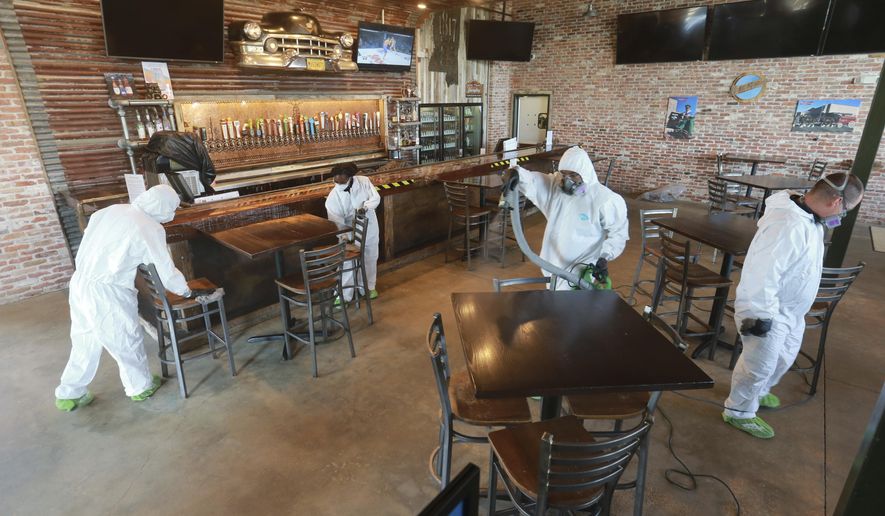 Workers from Servpro disinfect Mugshots restaurant in Tupelo, Mississippi, Friday, July 17, 2020, as the restaurant is preparing to open for business. (Thomas Wells/Northeast Mississippi Daily Journal via AP)