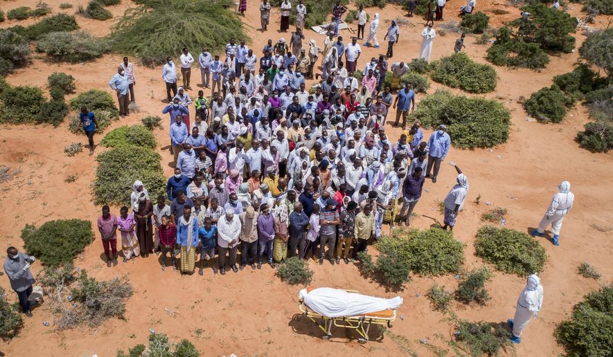 FILE - In this April 30, 2020, file photo, mourners gather to bury an elderly man believed to have died of the coronavirus but whose family asked not to be named because of the social stigma, in Mogadishu, Somalia. A dangerous stigma has sprung up around the coronavirus in Africa — fueled, in part, by severe quarantine rules in some countries as well as insufficient information about the virus. (AP Photo/File)