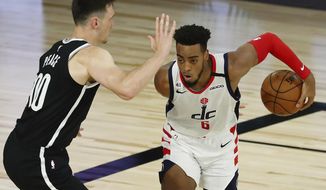 Washington Wizards forward Troy Brown Jr. (6) dribbles in front of Brooklyn Nets forward Rodions Kurucs (00) in the second half  of an NBA basketball game Sunday, Aug. 2, 2020, in Lake Buena Vista, Fla. (Kim Klement/Pool Photo via AP) ** FILE **