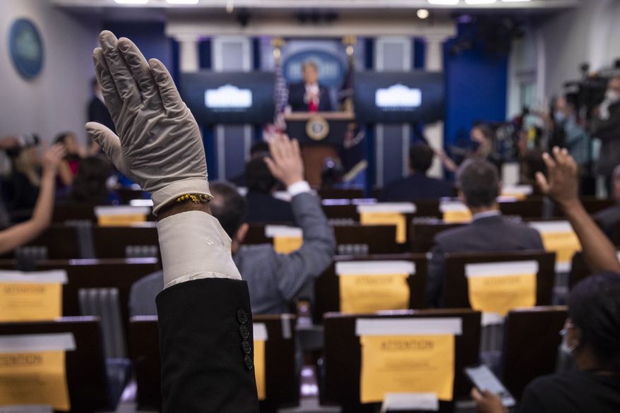 A reporter wearing a glove, raises his hand to ask President Donald Trump a question during a briefing with reporters in the James Brady Press Briefing Room of the White House, Monday, Aug. 3, 2020, in Washington. (AP Photo/Alex Brandon)  **FILE**