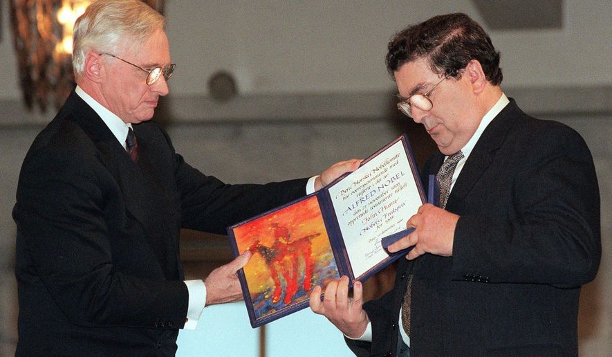 FILE - In this Dec. 10, 1998 file photo, John Hume, right, looks at the Nobel Peace Prize diploma which he received from Francis Sejersted, left, chairman of the Norwegian Nobel Peace Prize Committee during the award ceremony in Oslo Town Hall. The family of politician John Hume, who won Nobel Peace Prize for work to end violence in Northern Ireland, says he has died. He was 83. The Catholic leader of the moderate Social Democratic and Labour Party , Hume was regarded by many as the principal architect behind the peace agreement. (AP Photo/Bjoern Sigurdsoen/NTB/POOL)