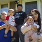 Areli Cardoso, left, holds infant son Arturo Sanchez next to her fifth-grade son Carlos Sanchez, center, and daughter Vanessa Cardoso, holding her daughter Amai Rani outside of their Bloomington, Minn., home on Thursday, July 17, 2020.  (Evan Frost/Minnesota Public Radio via AP)