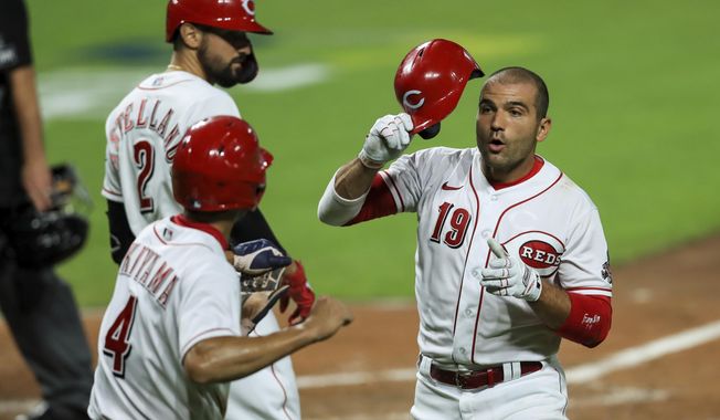 Cincinnati Reds&#x27; Joey Votto (19) is congratulated by teammates after hitting a two-run home run in the sixth inning of the team&#x27;s baseball game against the Cleveland Indians in Cincinnati, Monday, Aug. 3, 2020. (AP Photo/Aaron Doster)