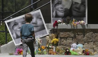 FILE - In this June 11, 2020, file photo, a boy looks at a memorial for Tylee Ryan, 17, and Joshua &amp;quot;JJ&amp;quot; Vallow, 7, at Porter Park in Rexburg, Idaho. An Idaho prosecutor is expected Monday, Aug. 3, 2020, to begin sketching out his case against an Idaho couple at the center of a bizarre missing children&#39;s case that ended in tragedy when their bodies were found buried on a rural eastern Idaho property earlier this year. (John Roark/The Idaho Post-Register via AP, File)
