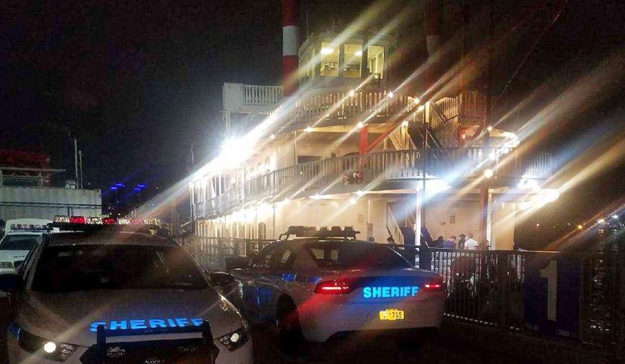 This photo provided by the New York City Sheriff, in New York, Monday, Aug. 3, 2020 shows two of the department's vehicles adjacent to the Liberty Belle boat in lower Manhattan, Saturday, Aug. 1, 2020. The New York City party cruise with more than 170 people on board was met by police when it returned to shore over the weekend, leading to the arrest of the captain and two owners. The cruise violated social distancing orders, the New York Sheriff's Department said in a tweet, and was serving alcohol on board without a liquor license. (New York City Sheriff via AP)