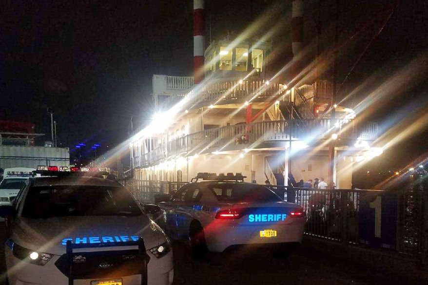 This photo provided by the New York City Sheriff, in New York, Monday, Aug. 3, 2020 shows two of the department's vehicles adjacent to the Liberty Belle boat in lower Manhattan, Saturday, Aug. 1, 2020. The New York City party cruise with more than 170 people on board was met by police when it returned to shore over the weekend, leading to the arrest of the captain and two owners. The cruise violated social distancing orders, the New York Sheriff's Department said in a tweet, and was serving alcohol on board without a liquor license. (New York City Sheriff via AP)